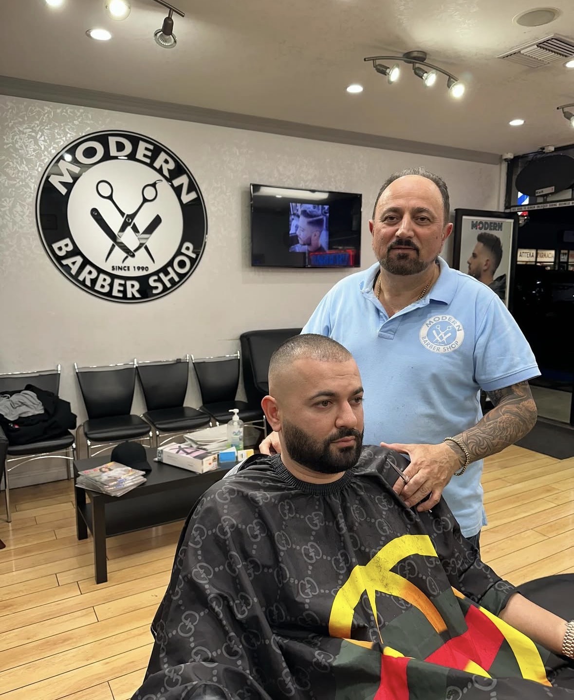 Master barber with client showcasing the Modern Barber Shop signage
